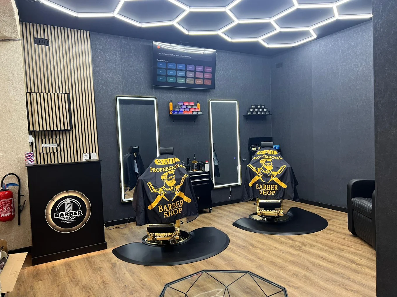 Intérieur du barber shop L'Art du Barber — fauteuils premium et plafond LED hexagonal